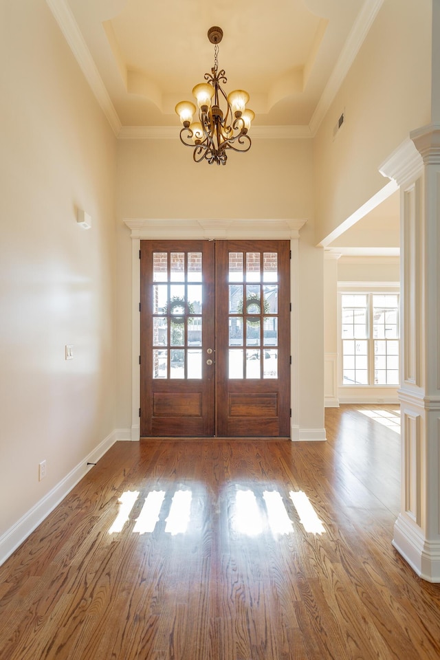 doorway to outside with french doors, a tray ceiling, hardwood / wood-style floors, and ornate columns