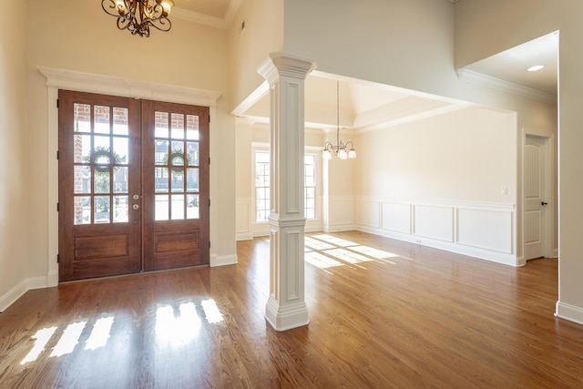 foyer entrance featuring an inviting chandelier, decorative columns, french doors, and a healthy amount of sunlight