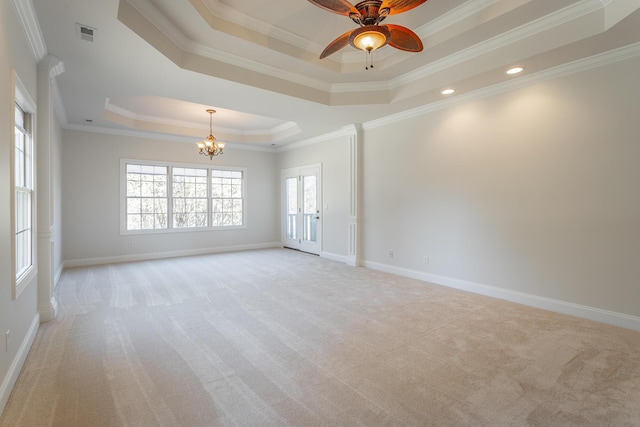 carpeted spare room featuring crown molding, a tray ceiling, and plenty of natural light