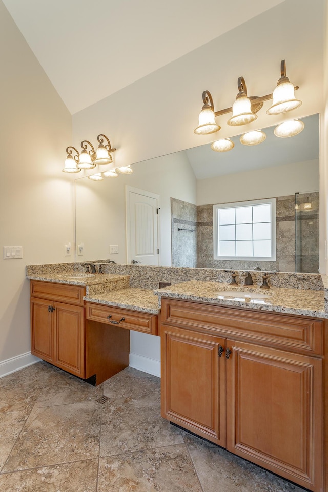 bathroom with vaulted ceiling, a tile shower, and vanity