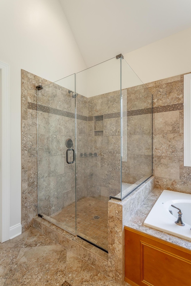 bathroom featuring shower with separate bathtub and vaulted ceiling