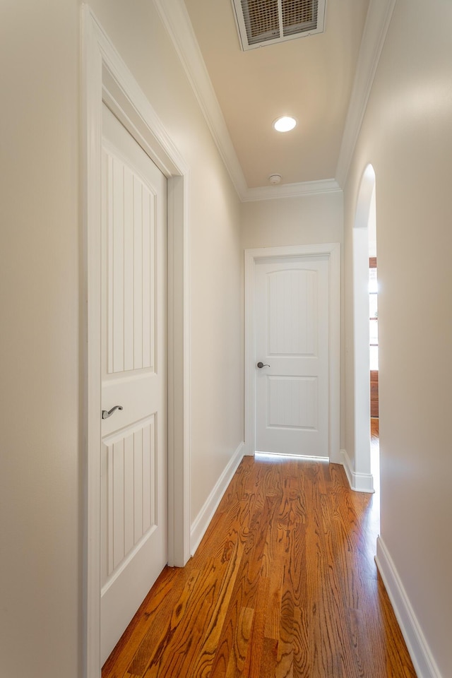 hallway featuring crown molding and hardwood / wood-style flooring