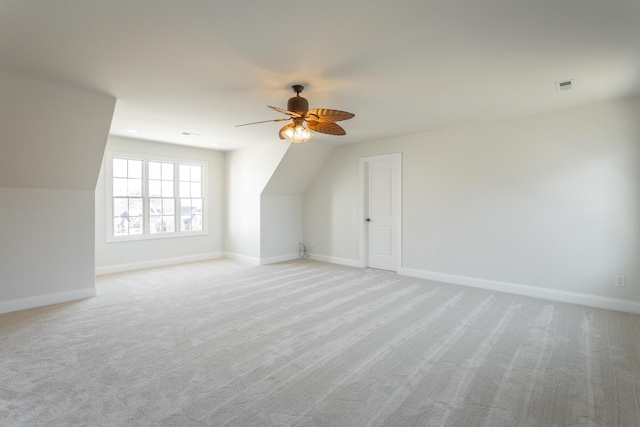 additional living space with ceiling fan and light carpet