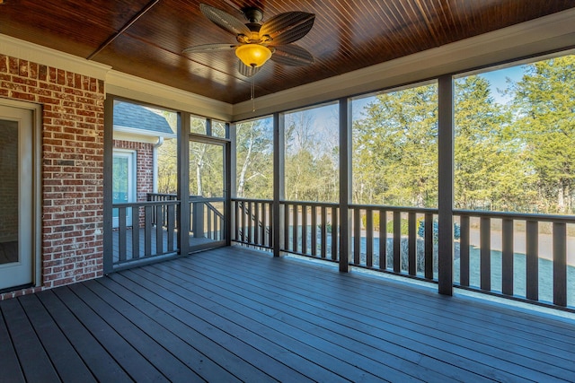 unfurnished sunroom with wood ceiling, ceiling fan, and a wealth of natural light