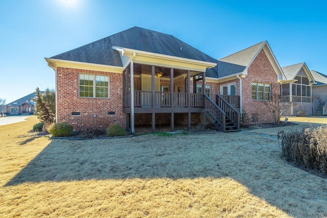 rear view of property featuring a lawn and a sunroom