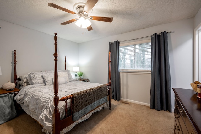 bedroom featuring a textured ceiling, light carpet, and ceiling fan