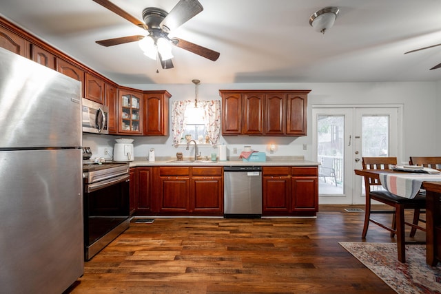 kitchen with hanging light fixtures, stainless steel appliances, ceiling fan, sink, and dark hardwood / wood-style floors