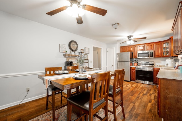 dining area with sink, dark hardwood / wood-style floors, and ceiling fan