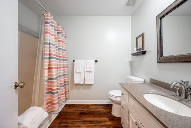 bathroom featuring toilet, hardwood / wood-style flooring, a shower with curtain, and vanity