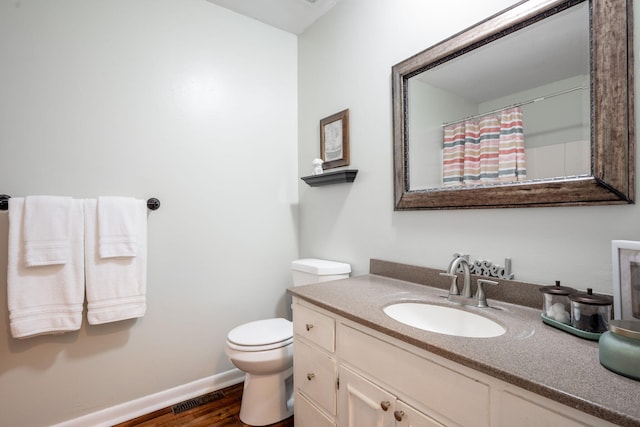 bathroom featuring toilet, wood-type flooring, a shower with curtain, and vanity