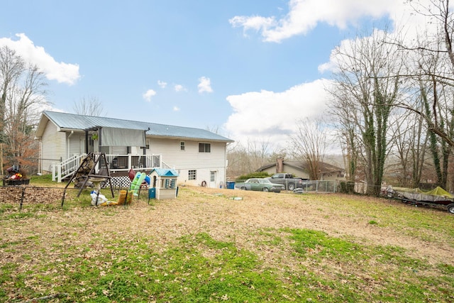 back of property featuring a yard and a wooden deck