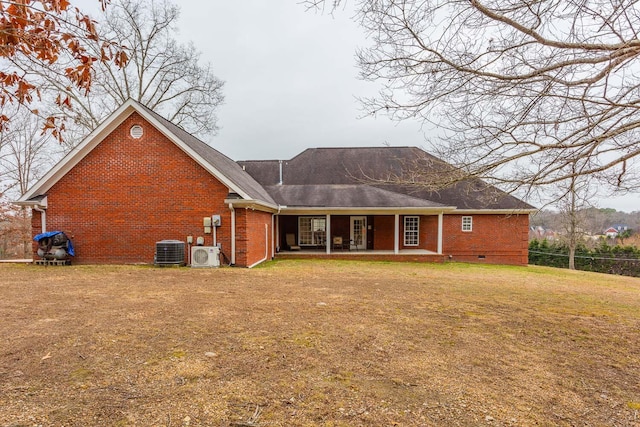 rear view of property featuring ac unit, a lawn, and central air condition unit