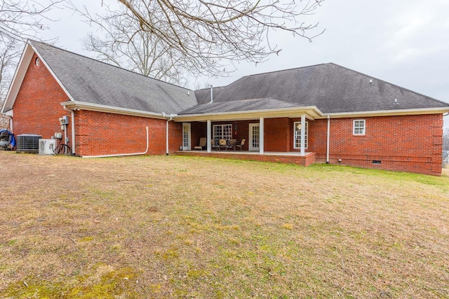 back of house with central AC unit, a patio area, and a lawn