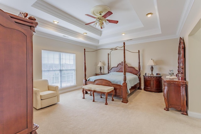 carpeted bedroom featuring crown molding, ceiling fan, and a raised ceiling