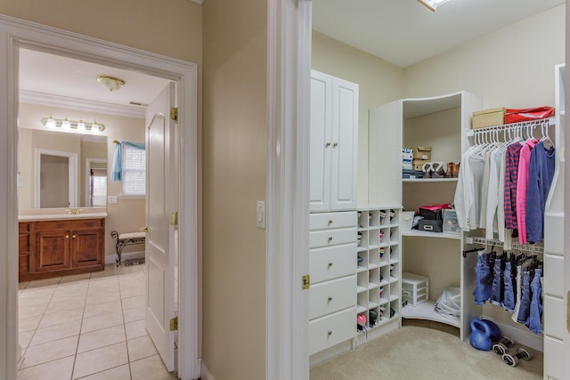 walk in closet featuring sink and light tile patterned floors