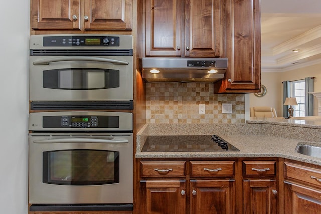 kitchen with double oven, backsplash, black electric stovetop, ornamental molding, and exhaust hood