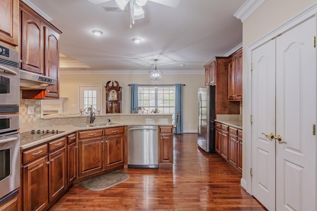 kitchen with sink, hanging light fixtures, kitchen peninsula, stainless steel appliances, and crown molding