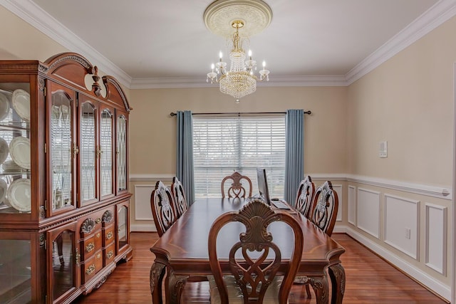 dining area featuring ornamental molding, wood-type flooring, and a chandelier