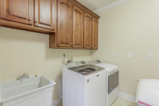 laundry area featuring separate washer and dryer, sink, cabinets, ornamental molding, and light tile patterned floors