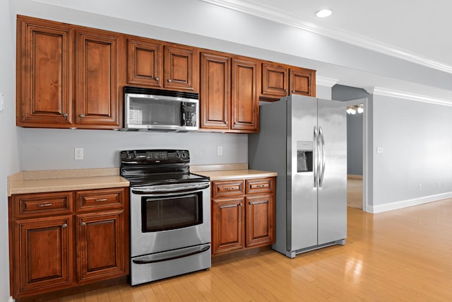 kitchen featuring ornamental molding, stainless steel appliances, and light hardwood / wood-style flooring