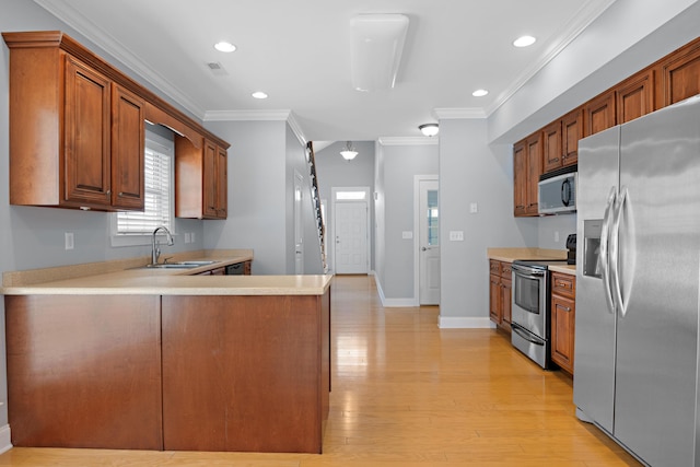 kitchen featuring sink, crown molding, stainless steel appliances, kitchen peninsula, and light wood-type flooring