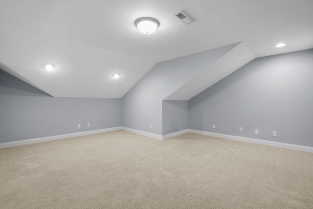 additional living space with light colored carpet and lofted ceiling