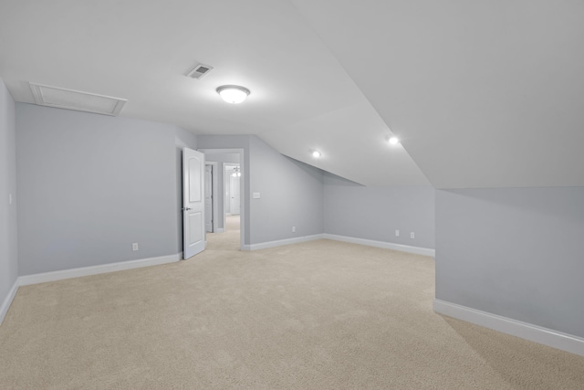 additional living space with vaulted ceiling and light colored carpet