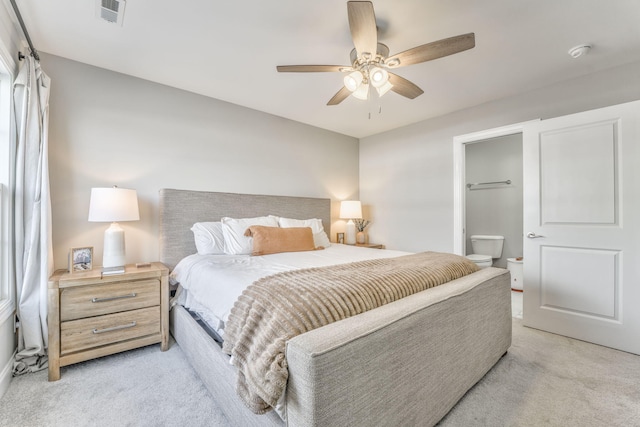 carpeted bedroom with ceiling fan and ensuite bathroom