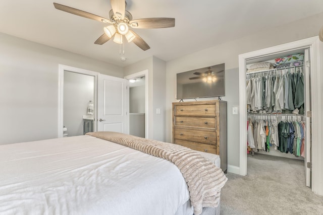 bedroom with ceiling fan, a spacious closet, light carpet, and a closet