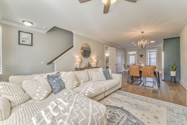 living room featuring crown molding, ceiling fan with notable chandelier, and hardwood / wood-style floors