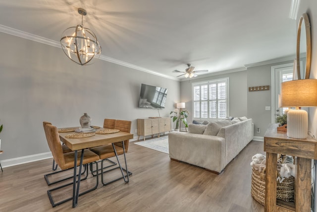 living room with crown molding, wood-type flooring, and ceiling fan with notable chandelier