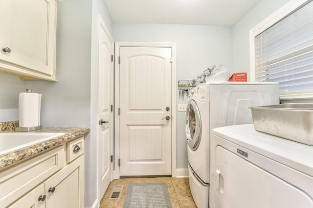 washroom with washing machine and dryer and cabinets