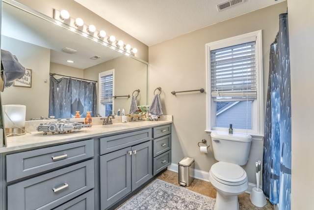 bathroom featuring vanity, toilet, curtained shower, and tile patterned flooring