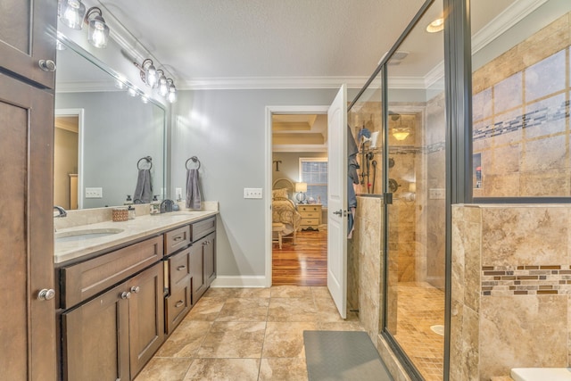 bathroom featuring vanity, a shower with door, ornamental molding, and a textured ceiling