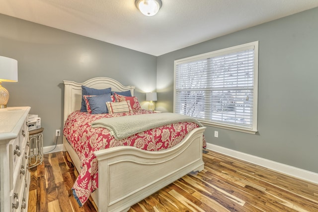 bedroom featuring dark hardwood / wood-style flooring and a textured ceiling