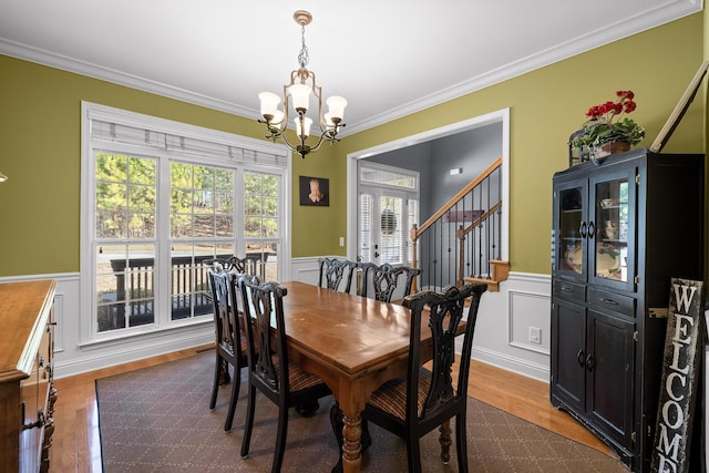 dining space featuring crown molding, hardwood / wood-style floors, and a notable chandelier