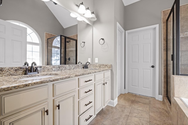 bathroom with lofted ceiling, vanity, and a shower with door