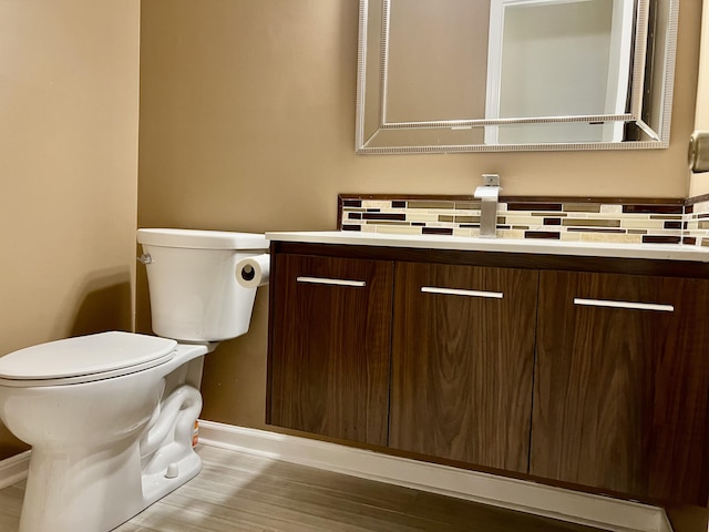 bathroom with tasteful backsplash, vanity, and toilet