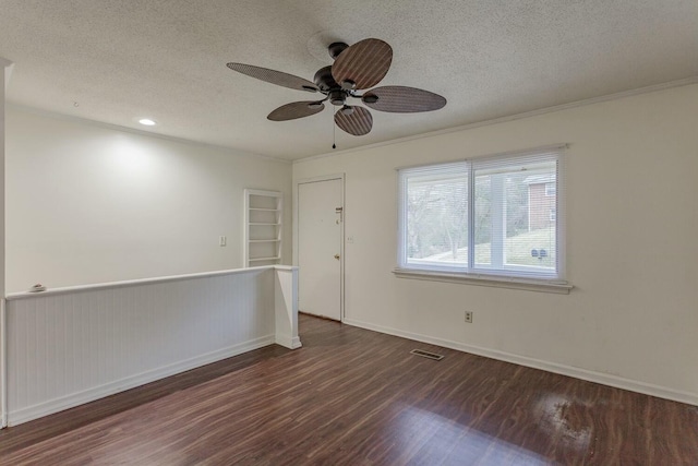 spare room with dark hardwood / wood-style flooring, crown molding, and a textured ceiling