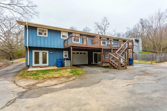 view of front facade with a garage, a wooden deck, and french doors