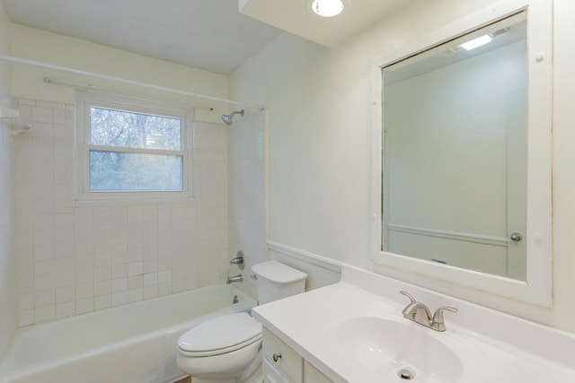 full bathroom featuring tiled shower / bath, vanity, and toilet