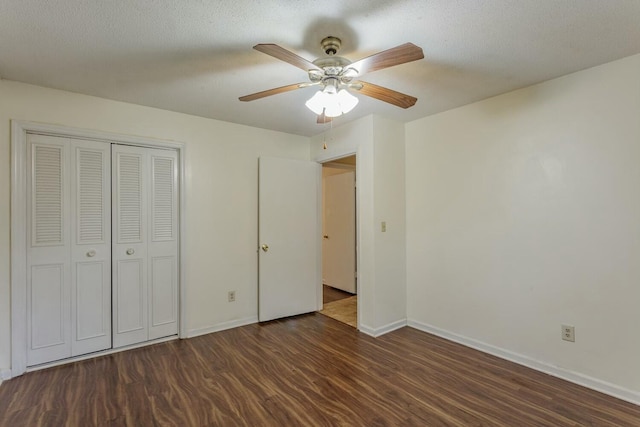 unfurnished bedroom with ceiling fan, dark hardwood / wood-style floors, a textured ceiling, and a closet