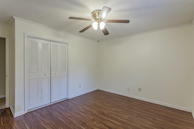 unfurnished bedroom with crown molding, a textured ceiling, dark hardwood / wood-style floors, a closet, and ceiling fan