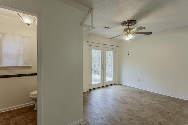 empty room with crown molding, ceiling fan, a textured ceiling, and french doors