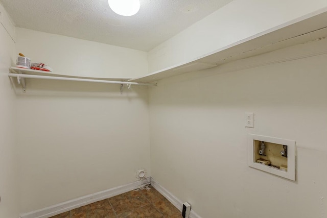 washroom with hookup for a washing machine and a textured ceiling