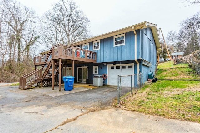 back of house featuring a wooden deck, a garage, and a yard