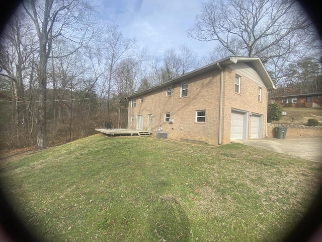 view of side of home featuring a garage, a yard, a deck, and central air condition unit