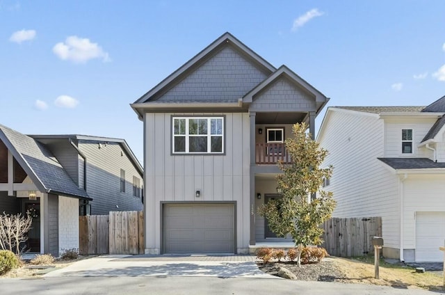 view of front facade featuring an attached garage, board and batten siding, fence, a balcony, and driveway