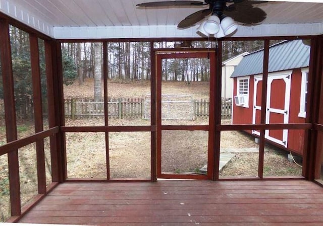 unfurnished sunroom featuring ceiling fan, plenty of natural light, and wooden ceiling