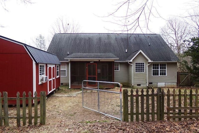 rear view of house featuring cooling unit, a storage shed, and a sunroom